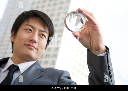 Imprenditore azienda sfera di cristallo Foto Stock