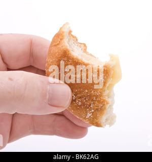 Mano azienda mezza ciambella mangiato contro uno sfondo bianco. Foto Stock