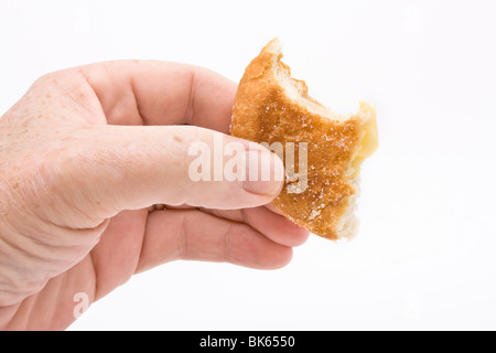 Mano azienda mezza ciambella mangiato contro uno sfondo bianco. Foto Stock