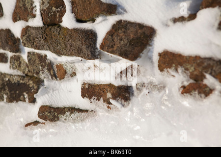 La neve soffiata contro una pietra a secco a parete, il Parco Nazionale di Peak District, UK, Inghilterra Foto Stock