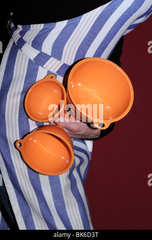 Donna che mantiene tre imbuti arancione Foto Stock