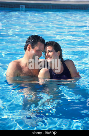 Rilasciato giovane abbracciando in piscina Foto Stock