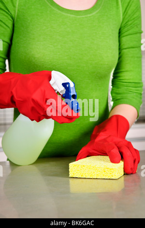 Ragazza cucina pulizia con spugna e guanti di gomma Foto Stock