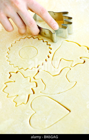 Il taglio di forme dei cookie in impasto arrotolato con taglierina Foto Stock