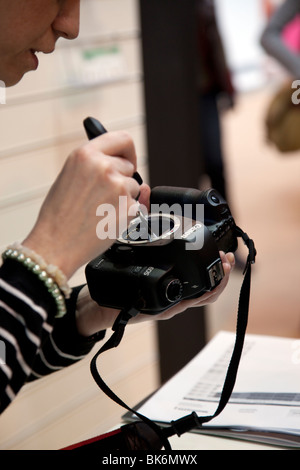 Dimostrando femmina come pulire il sensore della fotocamera in corrispondenza del fuoco della telecamera/fotografia mostra al NEC di Birmingham Inghilterra Foto Stock