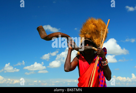 Guerriero Masai riproduzione tradizionale clacson . L'Africa. Kenya. Masai Mara Foto Stock