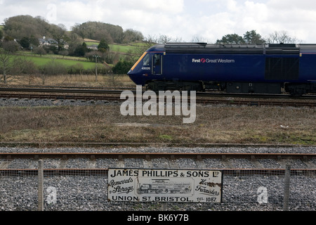 Un moderno Great Western treno passa le conserve di South Devon Railway e vinatge annuncio. Foto Stock