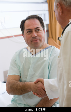 Il paziente e il medico stringono le mani Foto Stock