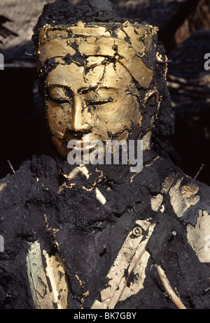 Il volto di Buddha emergendo dalle ceneri, fusione in bronzo, Mandalay Myanmar (Birmania), Asia Foto Stock