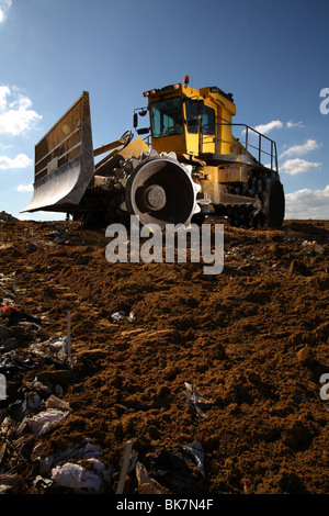 Scavatrice sul sito di discarica Foto Stock