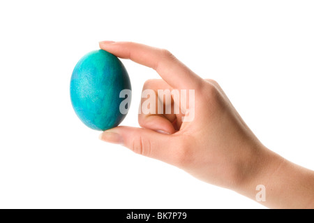 Mano che tiene la pasqua uova colorate Foto Stock