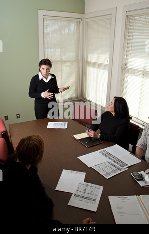 Direttrice donna di un'agenzia no-profit a San Antonio, Texas, conduce una riunione del personale nella sala conferenze dell'ufficio. ©Bob Daemmrich Foto Stock