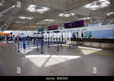 Svuotare i banchi check-in a causa delle cancellazioni dei voli all'interno del terminal dell'aeroporto di London Stansted in Essex Foto Stock