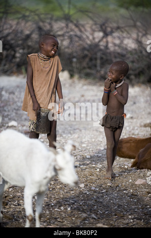 Due ragazzi himba condividere uno scherzo, Kaokoland, Namibia. Foto Stock