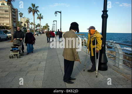 Un residente di Beirut camminando sul cornicione di Beirut Libano mentre gli altri con la giacca gialla di accattonaggio Foto Stock