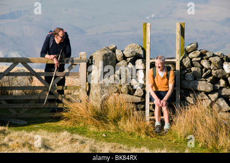 Due escursionisti in chat con Cwm Silyn, Snowdonia, Galles del Nord, Regno Unito Foto Stock