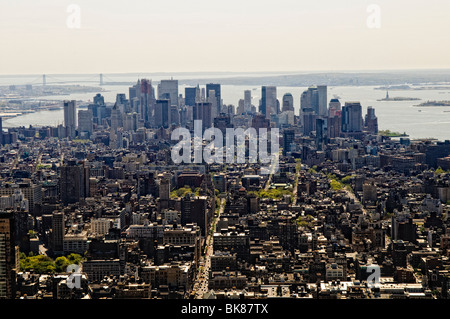 Lo skyline di Manhattan dall'Empire State Building New York City | NEW YORK, Stati Uniti - lo skyline del quartiere finanziario di Lower Manhattan si estende verso il porto di New York con questa vista dall'Empire State Building, con la Statua della libertà e il Verrazzano-Narrows Bridge visibili all'orizzonte. Il Verrazzano-Narrows Bridge, completato nel 1964, era il ponte sospeso più lungo del mondo all'epoca e collega Staten Island a Brooklyn attraverso lo stretto di Narrows. Foto Stock