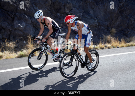 La Nuova Zelanda triatleta professionale Terenzo Bozzone, destra e americano Andy Potts sulla moto corso di Ironman Triathlon Foto Stock