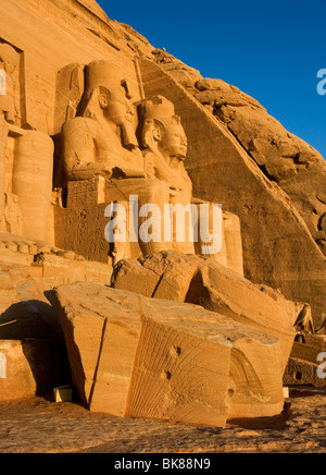 Statue intagliate di Ramses II a guardia del grande tempio di Abu Simbel a sunrise in Egitto. Foto Stock