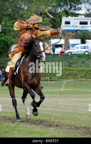 Un partecipante spara suo freccia al bersaglio a al galoppo, aprire Eocha campionato europeo 09, montato tiro con l'arco, con la steppa Foto Stock