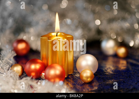 Masterizzazione di candela dorata con baubles per l'albero di Natale Foto Stock