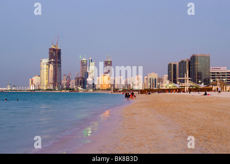 Vista del tramonto della spiaggia e gli edifici di Abu Dhabi negli Emirati Arabi Uniti. Foto Stock