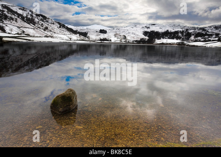 Il paesaggio di un lago nel distretto del lago con le montagne, sky e roccia in primo piano Foto Stock