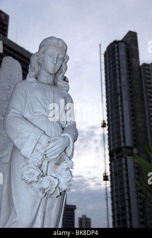 Statua dell'Angelo fuori dalla chiesa di El Santuario e dal moderno grattacielo , El Cangrejo , Città di Panama , Panama Foto Stock