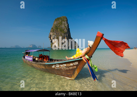 Donna su una barca dalla lunga coda sul Porto di Laem Phra Nang Beach, Krabi, Thailandia, Asia Foto Stock