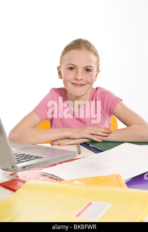 Ritratto di una ragazza sorridente con un computer e libri di esercizio Foto Stock