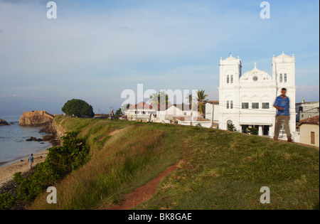 Uomo che cammina moschea passato sulle mura del Forte di Galle, Galle, Sri Lanka Foto Stock