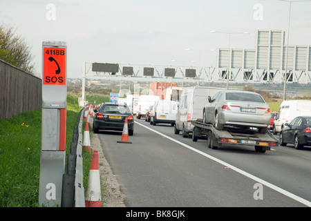 Telefono di emergenza e ripartiti in auto sull'autostrada hard spalla, M25 , Kent REGNO UNITO Foto Stock