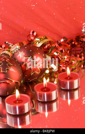 Tre delle tealight Natale candele con baubles rosso e nastro di ricci Foto Stock