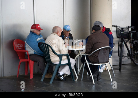 Gli uomini anziani gioca domino a Barceloneta Beach Foto Stock
