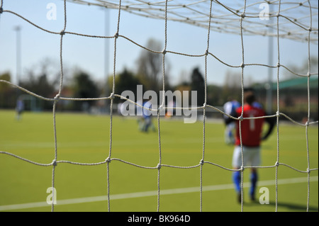 Una chiusura di un obiettivo di calcio con compensazione retroilluminazione sunshine net. Dietro sono i calciatori. Foto Stock