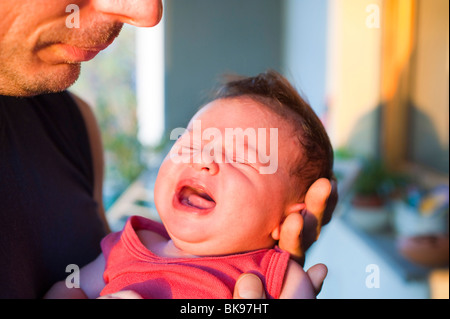 Padre holding urlando neonato Foto Stock