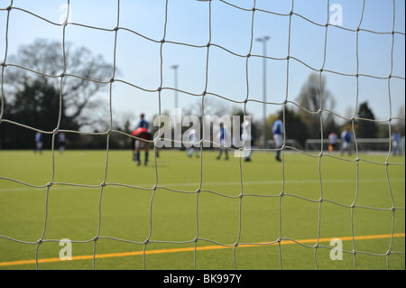 Una chiusura di un obiettivo di calcio con compensazione retroilluminazione sunshine net. Dietro sono i calciatori. Foto Stock
