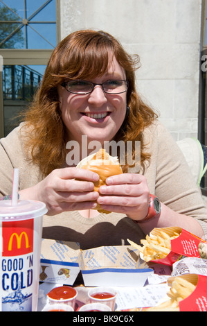 Donna sovrappeso mangiare McDonald's pasto veloce Foto Stock