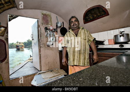 Lo chef nella sua cucina casa galleggiante su una crociera backwaters nel Kerala, India. Foto Stock