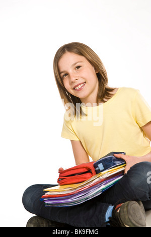 Ritratto di una ragazza sorridente con una pila di libri di esercizio Foto Stock