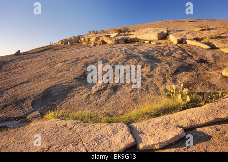 Massi di granito e sfogliato strati di granito, gli escursionisti a lunga distanza al tramonto vicino al vertice della roccia incantata, Texas, Stati Uniti d'America Foto Stock