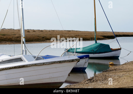 Blakeney porto sulla costa del nord Norfolk con barche ormeggiate nel torrente e contro la banchina. Foto Stock