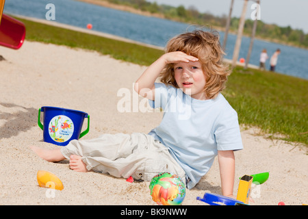 Il ragazzo, tre anni, seduti nella sandbox Foto Stock