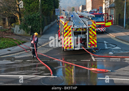 Un vigile del fuoco del Mid-Wales Fire and Rescue Service sul lavoro che ha eliminato le attrezzature dopo un incendio della casa, Regno Unito Foto Stock