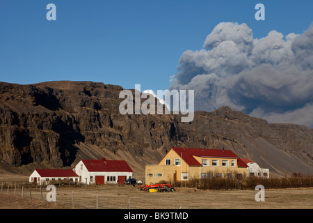 Una fattoria e nuvole nere di ceneri vulcaniche proveniente dall'eruzione vulcanica in Eyjafjallajokull, Islanda - Foto Stock