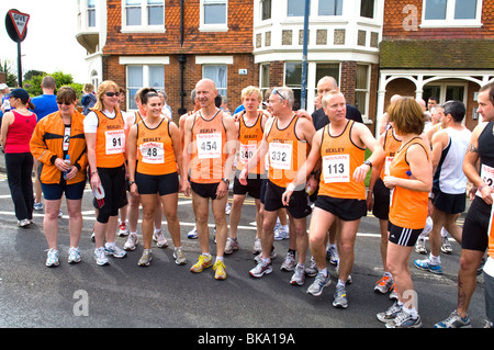 I gruppi di raccolta di guide in strada prima di iniziare a 10km carità eseguire da Bexley che sono tutti indossano arancione. Foto Stock