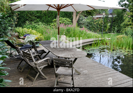 Balcone con tavolo e sedie in legno riciclato riadattato, cuscini, area da  pranzo esterna con patio, viole, succulenti e micro green UK Foto stock -  Alamy