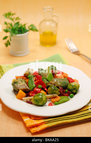 Mescolare le verdure fritte con prosciutto e peperoni. Ricetta disponibile. Foto Stock