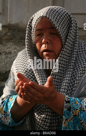 Uzbek donna prega al mausoleo di Baha-ud-din Naqshband al-Bukhari vicino a Bukhara, Uzbekistan. Foto Stock