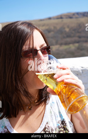 Donna di bere una pinta di sidro al sole. Foto Stock